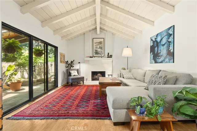 a living room with furniture large window and a fireplace