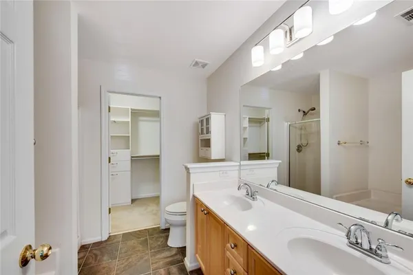 a bathroom with a double vanity sink mirror and toilet