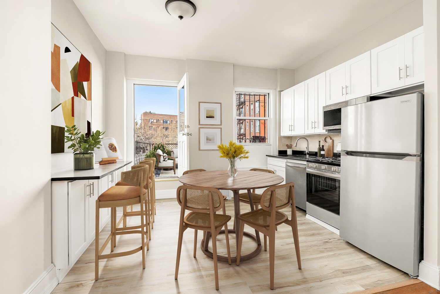 71 MacDougal Street, Unit 2 Manhattan, NY 10012 - Photo 3 of 10 a kitchen with stainless steel appliances a dining table chairs refrigerator and sink