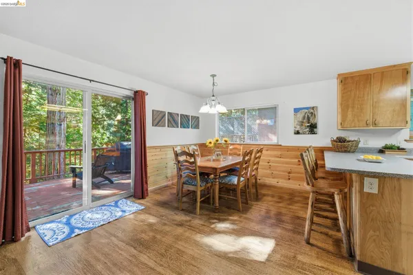 a view of a dining room and livingroom with furniture wooden floor a chandelier