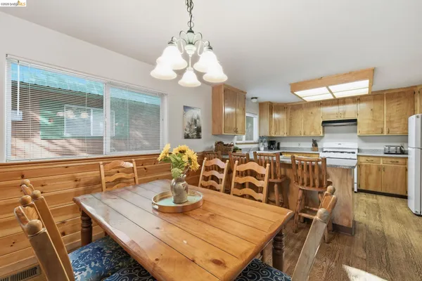 a kitchen with refrigerator a stove a sink cabinets and wooden floor