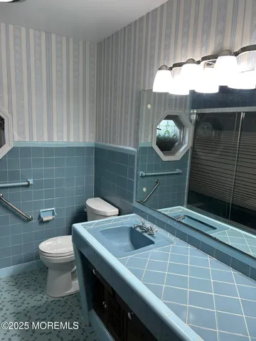 a bed sitting in a spacious bedroom next to a window and a wooden floor