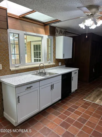 a kitchen with granite countertop a refrigerator and a stove top oven