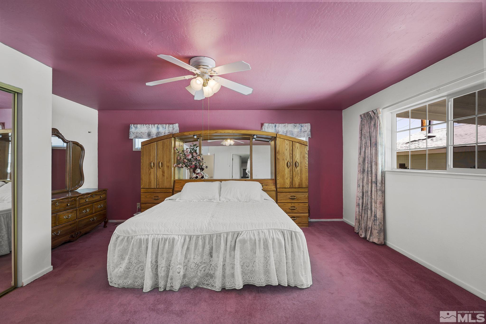 946 Lester Avenue Reno, NV 89502 - Photo 11 of 18 a spacious bedroom with a bed and a chandelier
