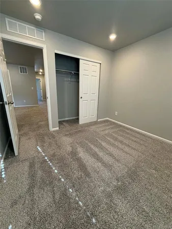 an empty room with closet and mirror
