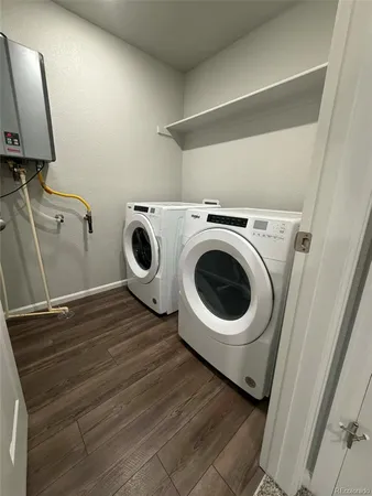 a utility room with wooden floor washer and dryer
