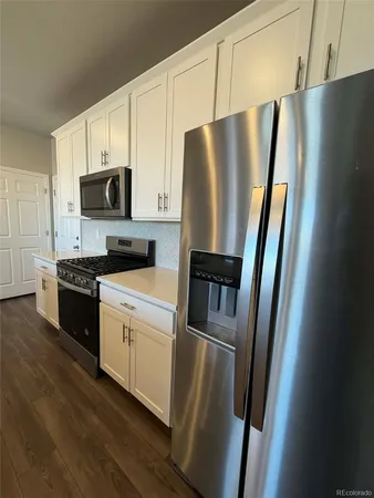 a kitchen with stainless steel appliances a refrigerator a stove top oven a sink and cabinets