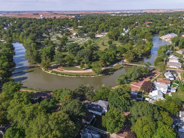 an aerial view of residential houses with outdoor space and trees