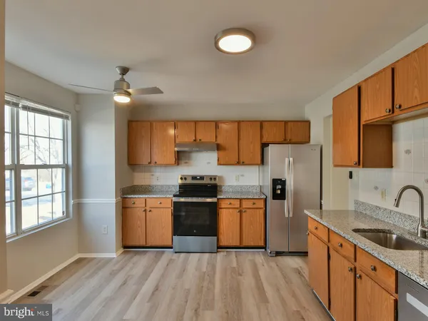 a kitchen with refrigerator a sink and chairs