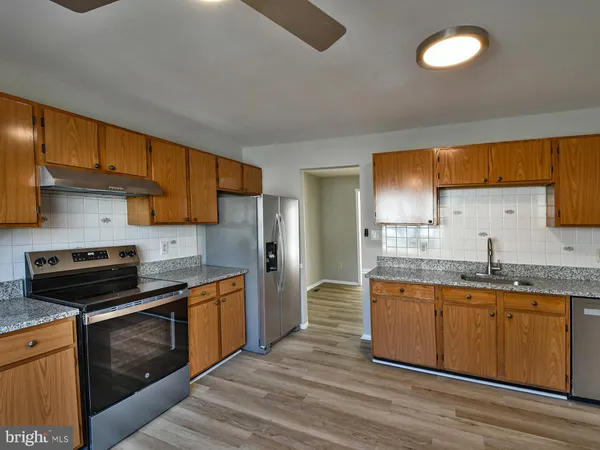 a kitchen with stainless steel appliances granite countertop a sink and a wooden cabinets