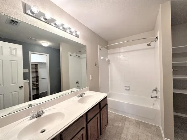 a bathroom with a double vanity sink toilet mirror and bathtub