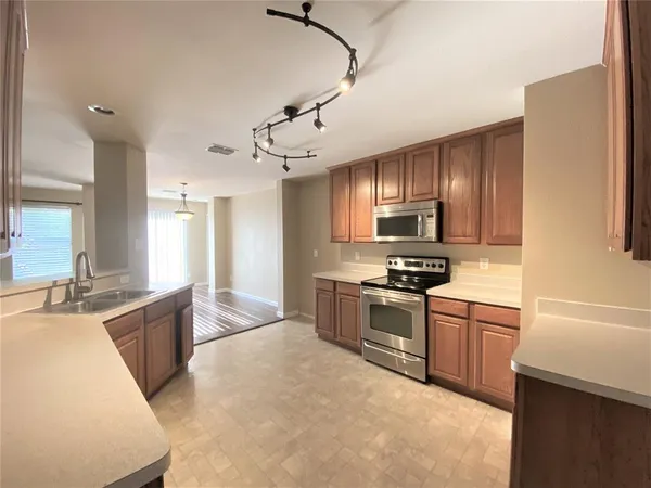 a kitchen with a sink refrigerator and cabinets