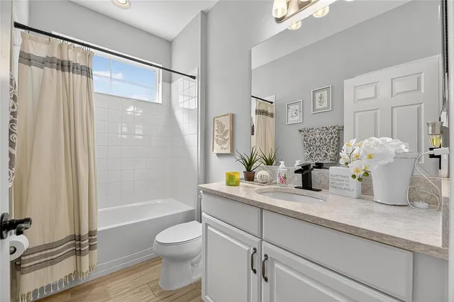 a living room with furniture floor to ceiling window and wooden floor