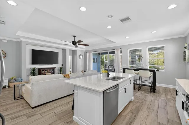 a kitchen with a sink and a flat screen tv