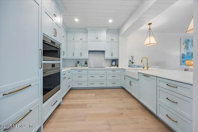 a large kitchen with a large counter top stainless steel appliances and cabinets