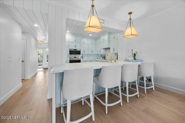a dining room with furniture a chandelier and wooden floor
