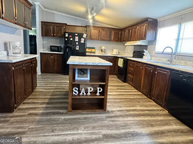 a kitchen with stainless steel appliances wooden cabinets a sink and a stove