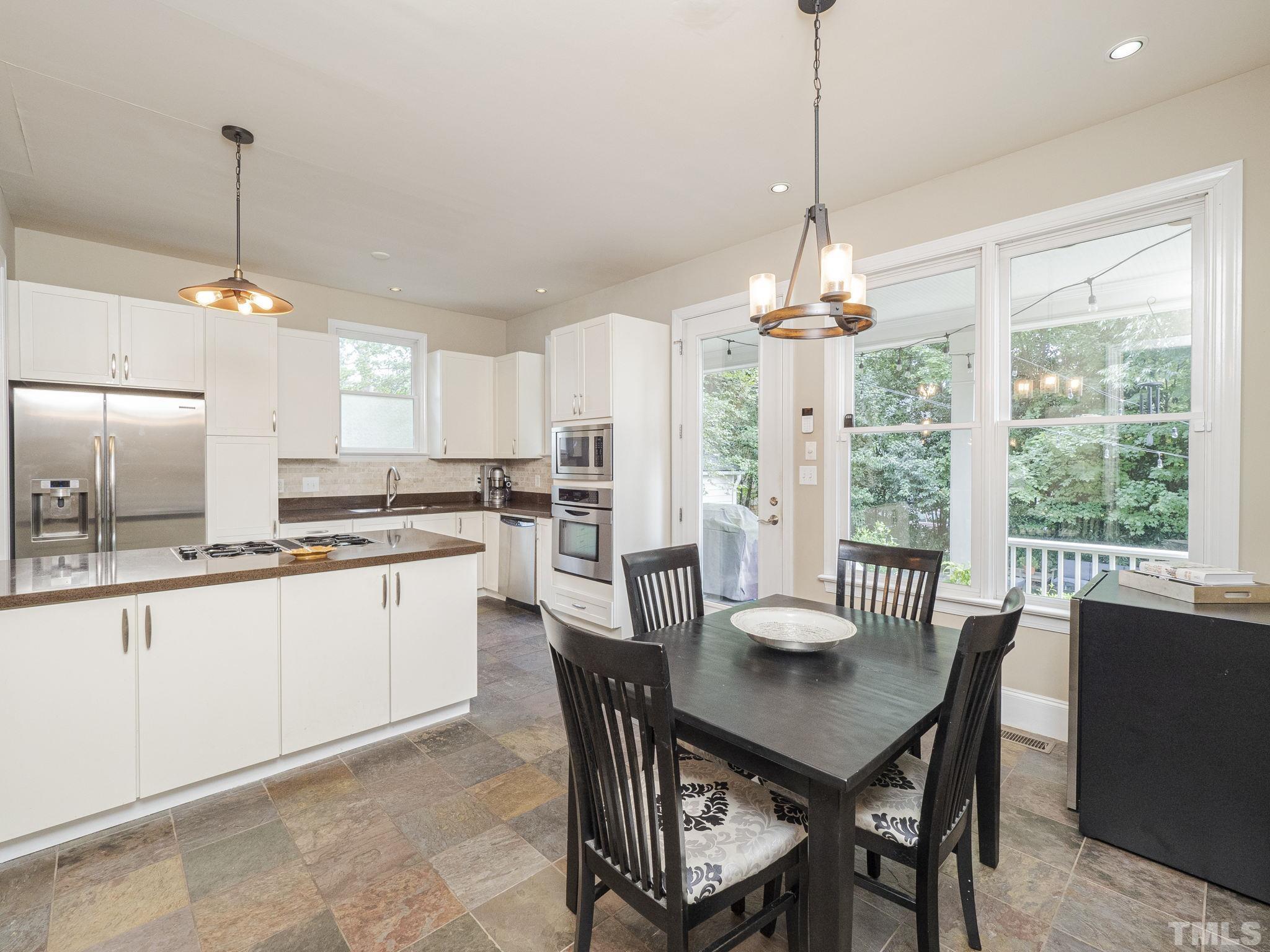 404 Brooks Avenue Raleigh, NC 27607 - Photo 8 of 18 a kitchen with granite countertop white cabinets and stainless steel appliances