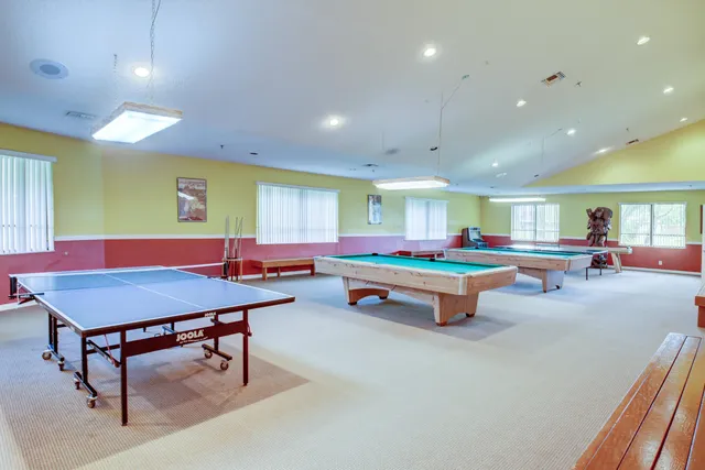 a room with furniture pool table and windows