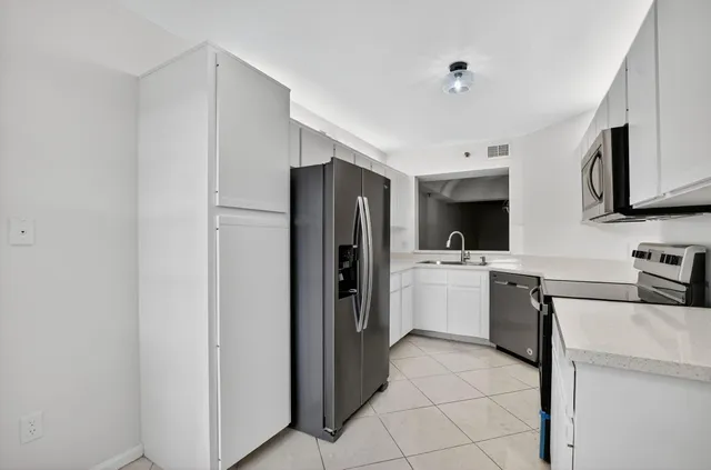 a kitchen with a refrigerator sink and stove top oven
