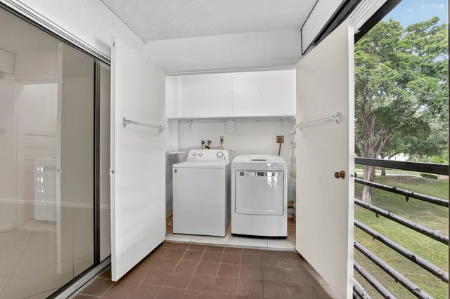 a utility room with cabinets washer and dryer