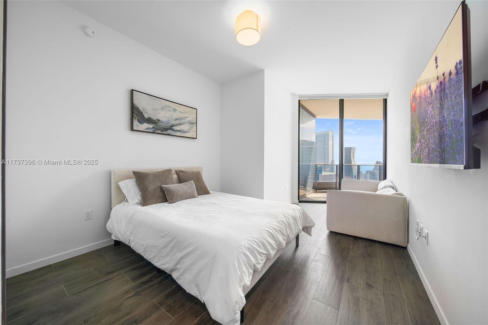 1000 Brickell Plaza, Unit PH5002 Miami, FL 33131 - Photo 34 of 68 a bedroom with a bed and a couch