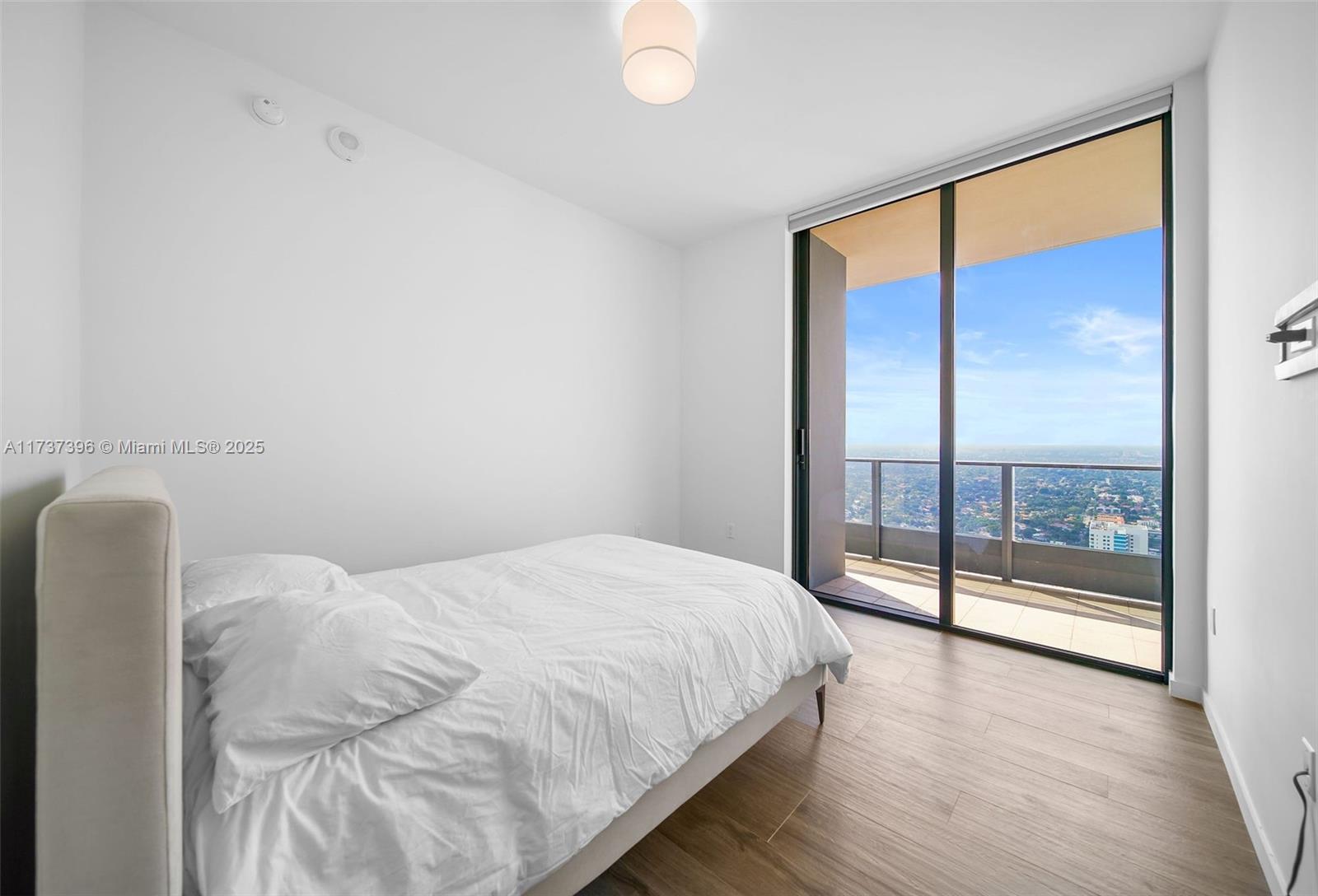1000 Brickell Plaza, Unit PH5002 Miami, FL 33131 - Photo 39 of 68 a bedroom with a large bed and a large window