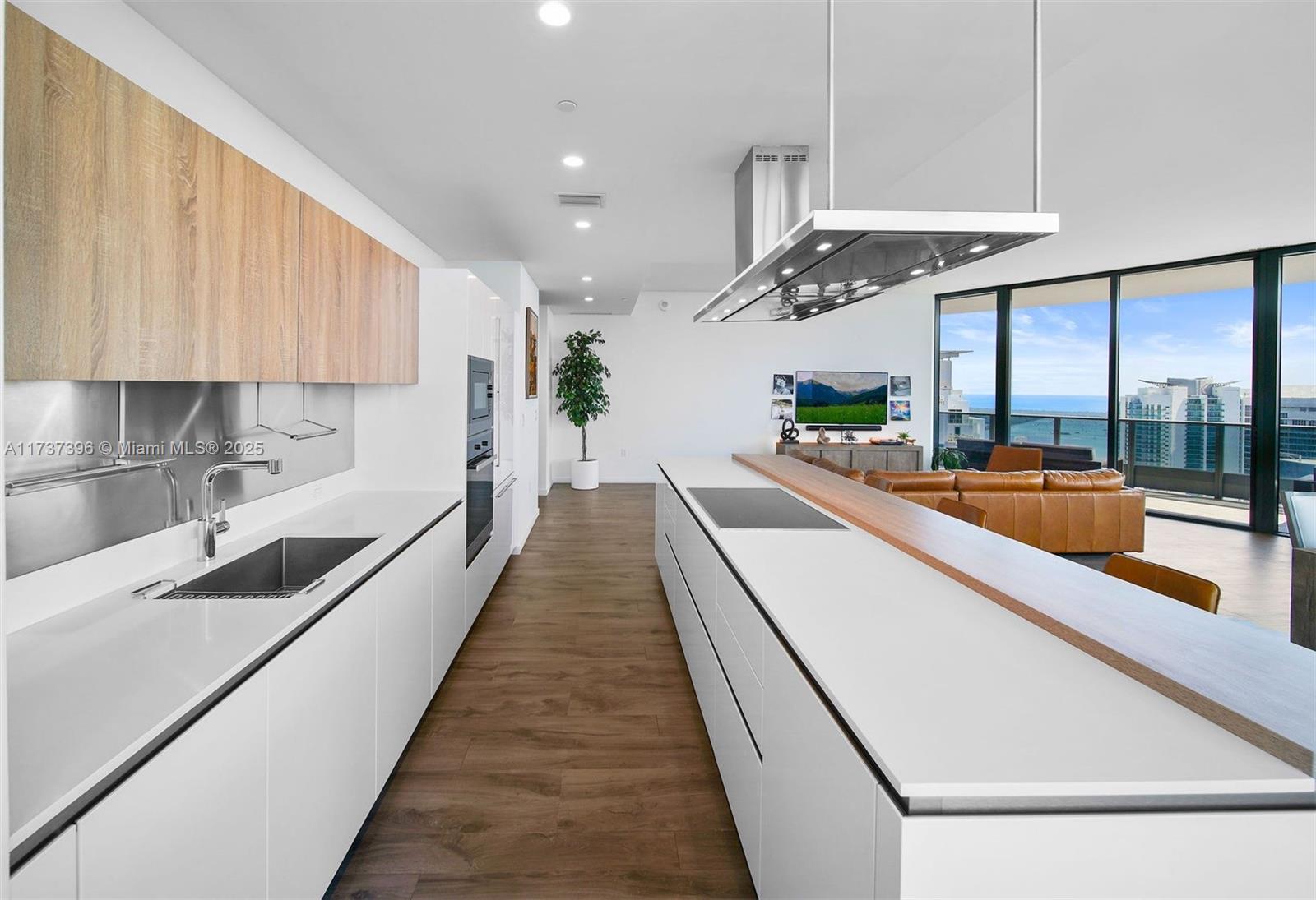 1000 Brickell Plaza, Unit PH5002 Miami, FL 33131 - Photo 4 of 68 a large kitchen with stainless steel appliances a large counter top a stove a chimney a sink and a refrigerator