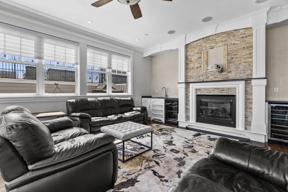 161 Tudor Street, Unit 4 Boston, MA 02127 - Photo 21 of 34 a living room with furniture a fireplace and a floor to ceiling window