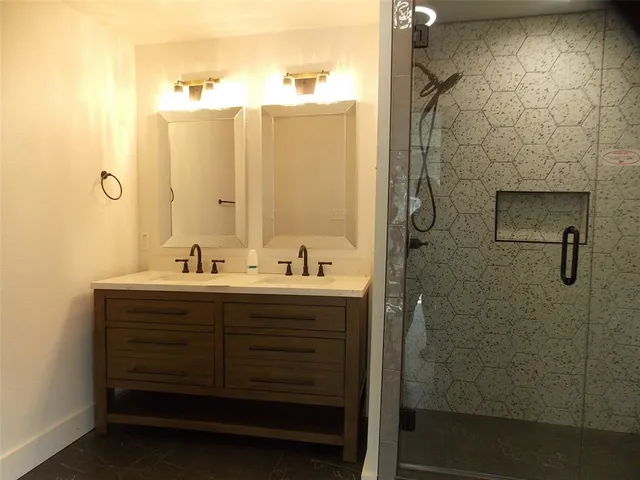 a bathroom with a sink mirror and shower