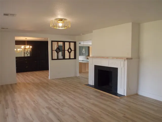 a view of a livingroom with wooden floor and a fireplace