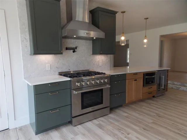 a kitchen with stainless steel appliances a stove a sink and a refrigerator