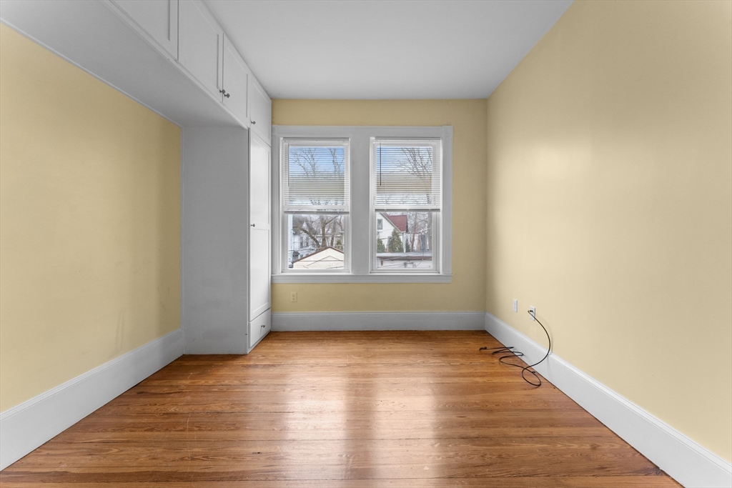 571 Washington Street, Unit 2 Boston, MA 02135 - Photo 11 of 13 an empty room with wooden floor and windows