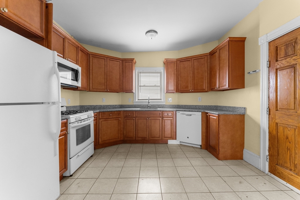 571 Washington Street, Unit 2 Boston, MA 02135 - Photo 2 of 13 a kitchen with stainless steel appliances granite countertop a refrigerator and a stove top oven