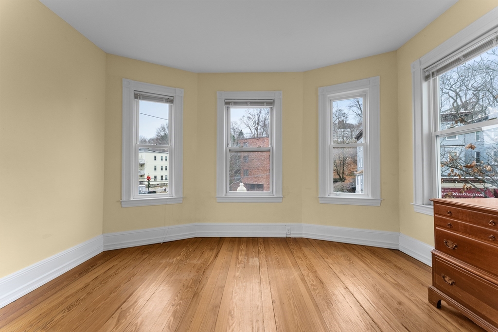 571 Washington Street, Unit 2 Boston, MA 02135 - Photo 3 of 13 a view of an empty room with wooden floor and a window