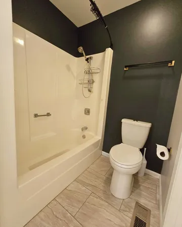 a bathroom with a toilet and a shower