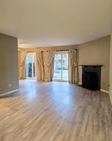 an empty room with wooden floor and fireplace