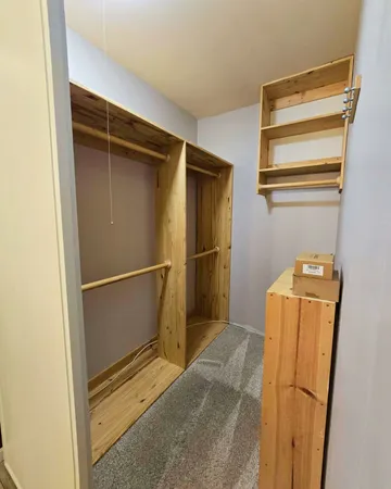 a view of walk in closet with empty racks