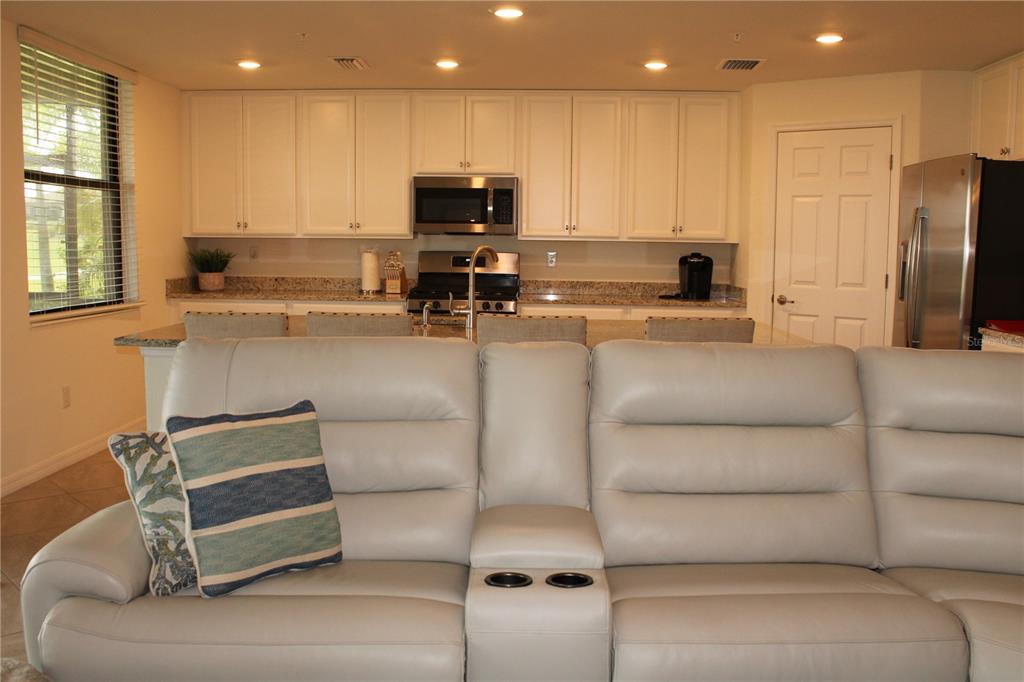 18017 Gawthrop Drive, Unit 104 Bradenton, FL 34211 - Photo 12 of 54 a view of kitchen with kitchen island stainless steel appliances wooden cabinets and refrigerator