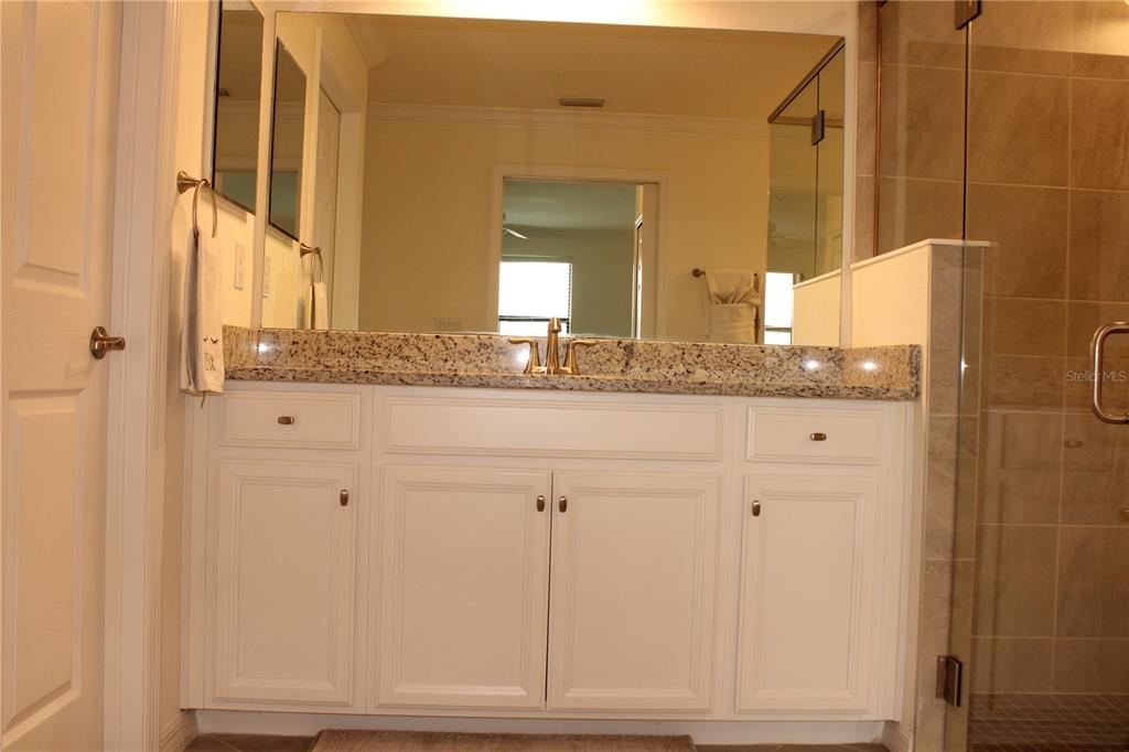 18017 Gawthrop Drive, Unit 104 Bradenton, FL 34211 - Photo 17 of 54 a bathroom with a granite countertop sink and a mirror