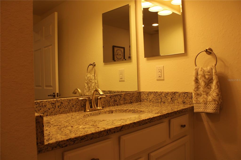 18017 Gawthrop Drive, Unit 104 Bradenton, FL 34211 - Photo 24 of 54 a bathroom with a granite countertop sink and a mirror
