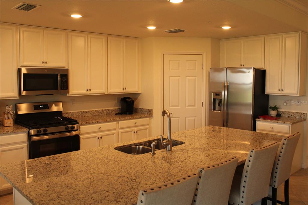 18017 Gawthrop Drive, Unit 104 Bradenton, FL 34211 - Photo 4 of 54 a kitchen with stainless steel appliances granite countertop a stove a sink a refrigerator and a microwave
