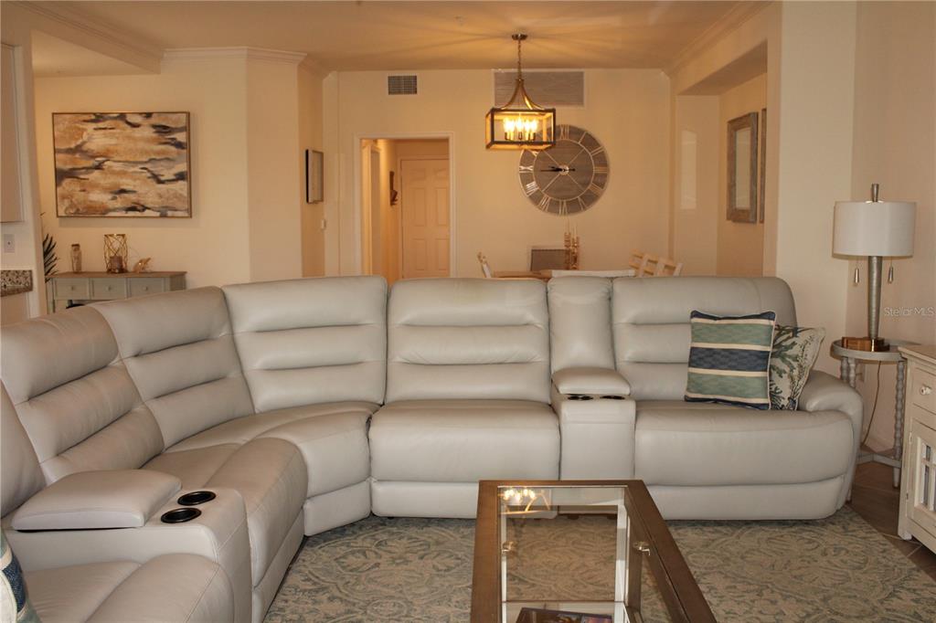 18017 Gawthrop Drive, Unit 104 Bradenton, FL 34211 - Photo 9 of 54 a living room with furniture and a chandelier