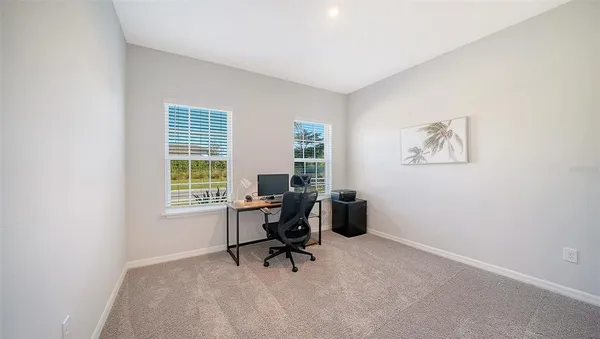 a backyard of a house with large trees and outdoor seating