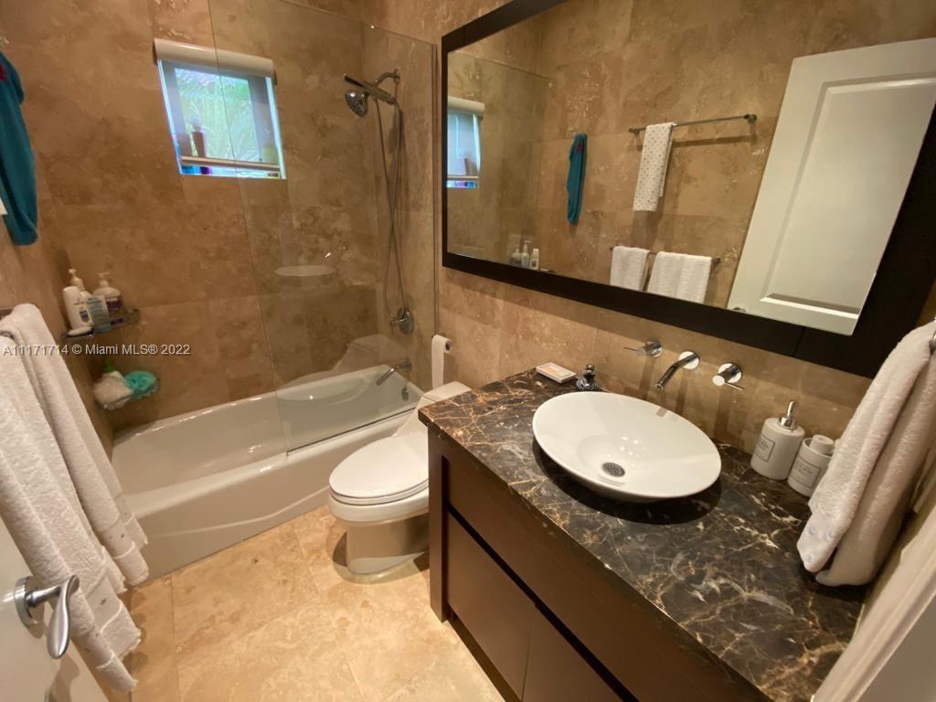 584 Fernwood Road Key Biscayne, FL 33149 - Photo 11 of 24 a bathroom with a granite countertop toilet sink and mirror