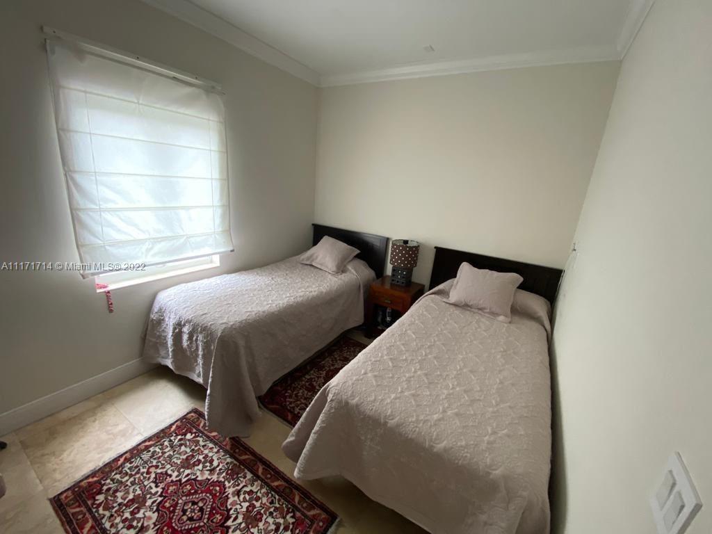 584 Fernwood Road Key Biscayne, FL 33149 - Photo 17 of 24 a bedroom with two beds and a window