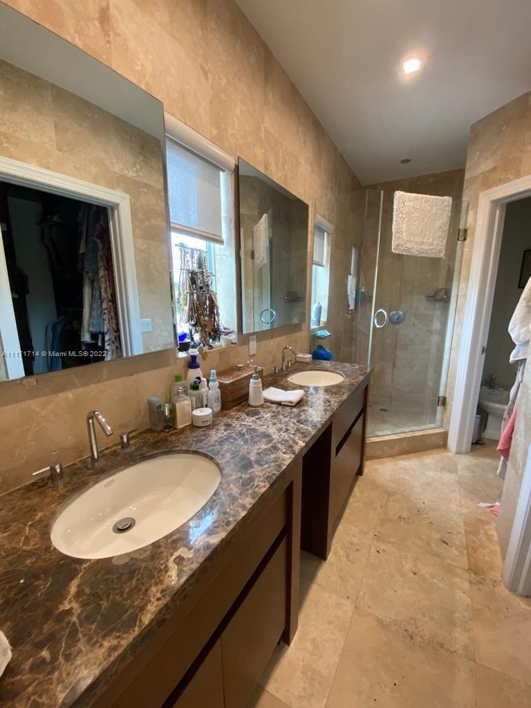 584 Fernwood Road Key Biscayne, FL 33149 - Photo 6 of 24 a bathroom with a sink double vanity granite and a large mirror
