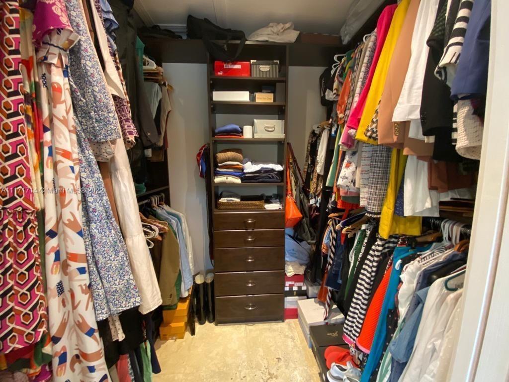 584 Fernwood Road Key Biscayne, FL 33149 - Photo 8 of 24 a view of walk in closet with clothes