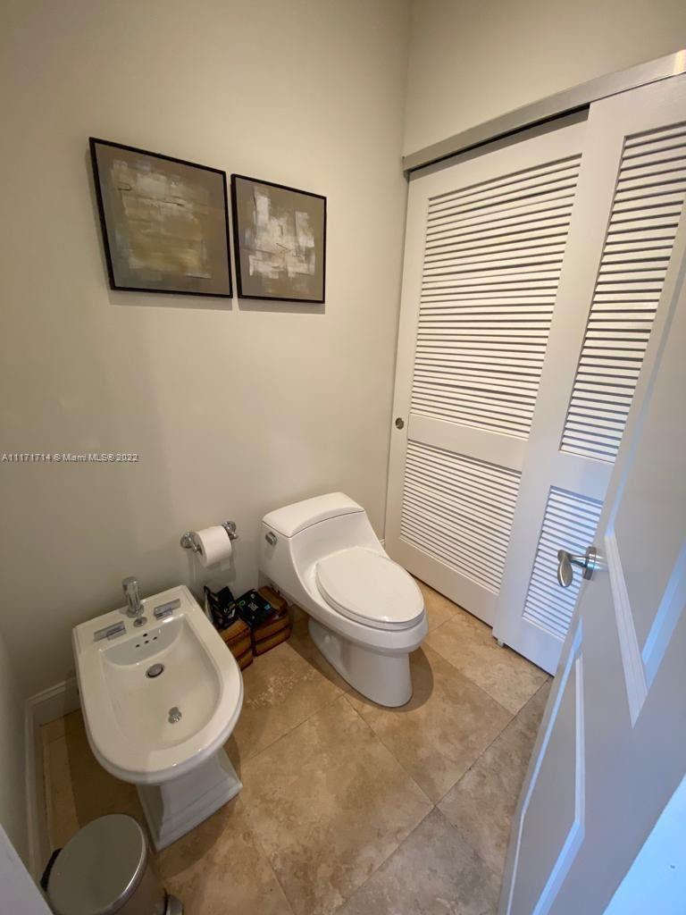 584 Fernwood Road Key Biscayne, FL 33149 - Photo 9 of 24 a bathroom with a toilet a sink and mirror