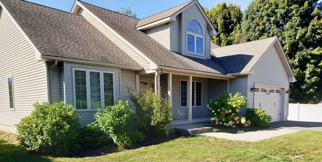 a view of a house with brick walls and a flower garden